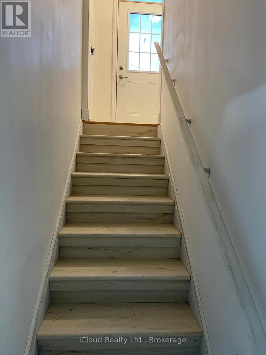 A staircase with a white door at the top.