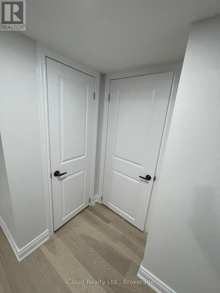 Two white doors in a room with wooden flooring.