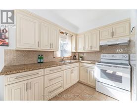 A kitchen with a white oven and cabinets.