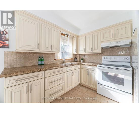 A kitchen with a white oven and cabinets.