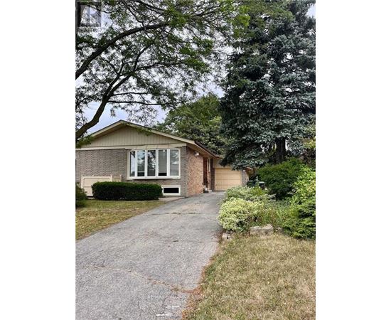 A house with a driveway and trees in the background.