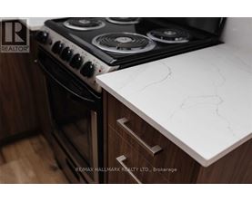 A modern kitchen with a white countertop and a black stove.