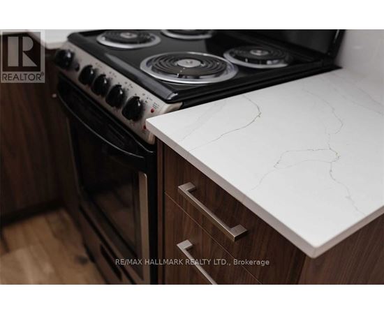 A modern kitchen with a white countertop and a black stove.