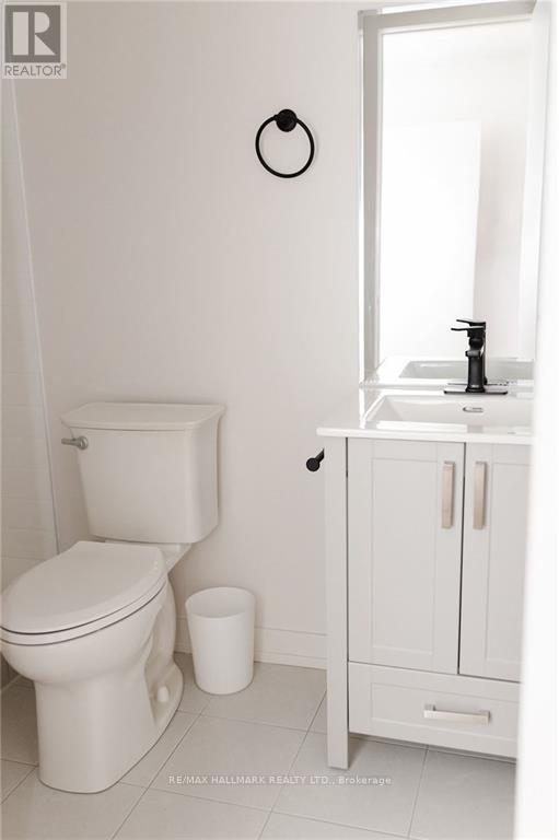 A white toilet sits next to a white sink in a bathroom.