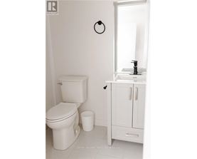 A white toilet sits next to a white sink in a bathroom.