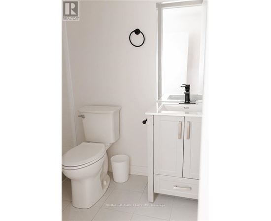 A white toilet sits next to a white sink in a bathroom.