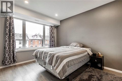 A bedroom with a large bed and a window overlooking a cityscape.