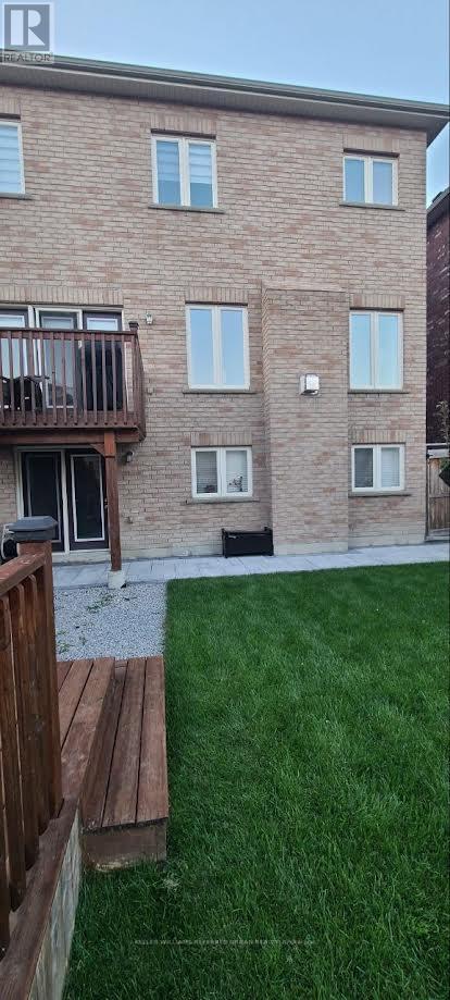 A brick building with a balcony and a green lawn.