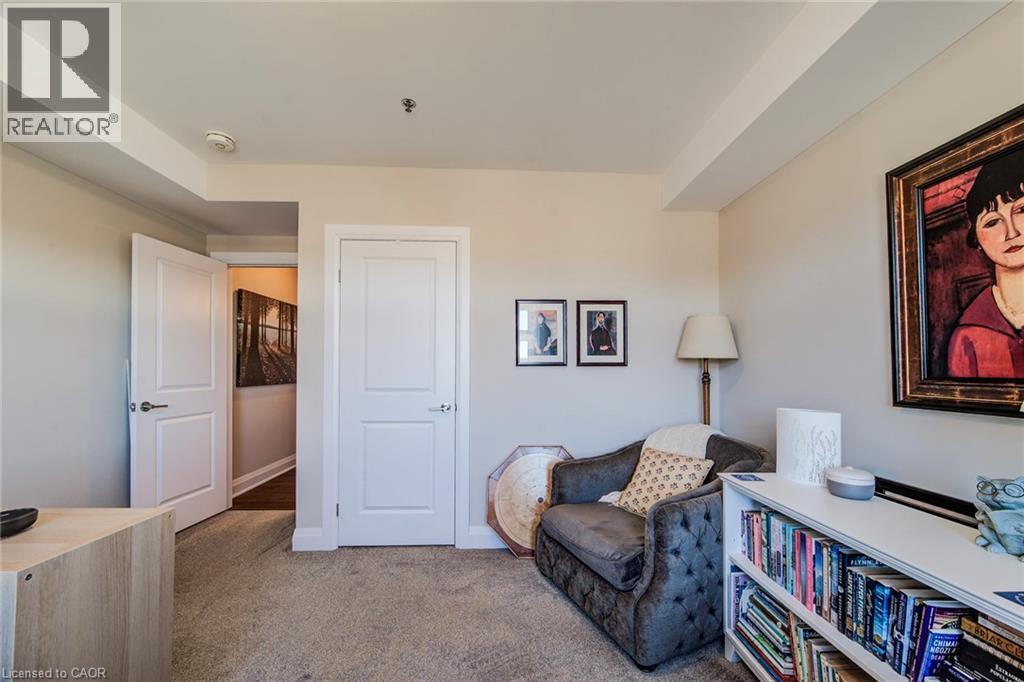 A living room with a couch, a bookshelf, and a painting on the wall.