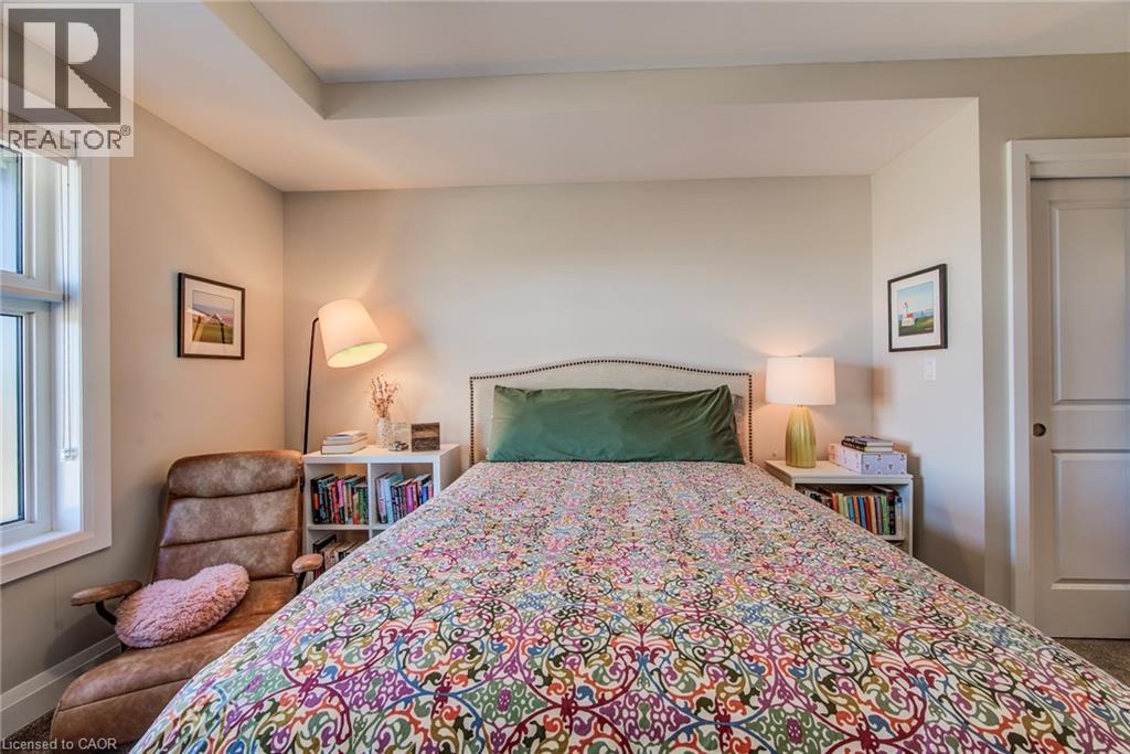 A bedroom with a large bed and a chair.