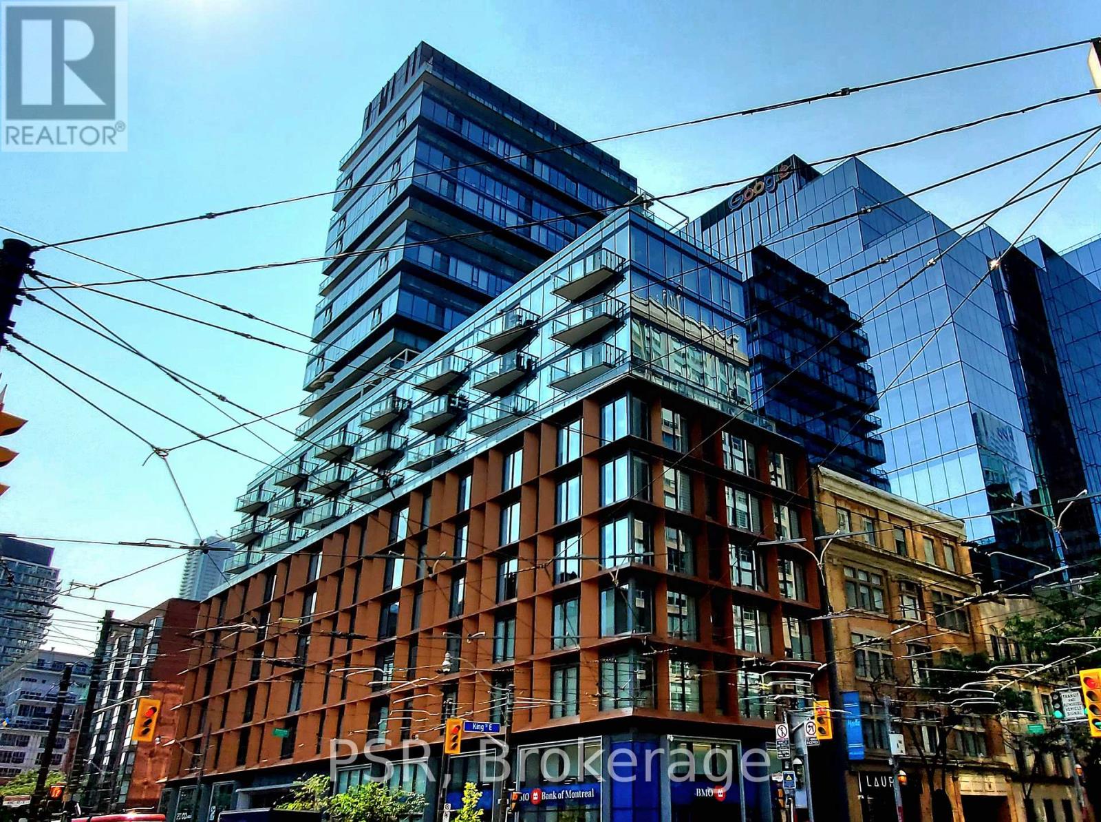 A cityscape with a mix of modern and older buildings, with the sun casting shadows on the scene.