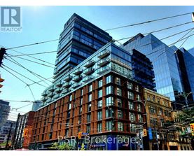 A cityscape with a mix of modern and older buildings, with the sun casting shadows on the scene.