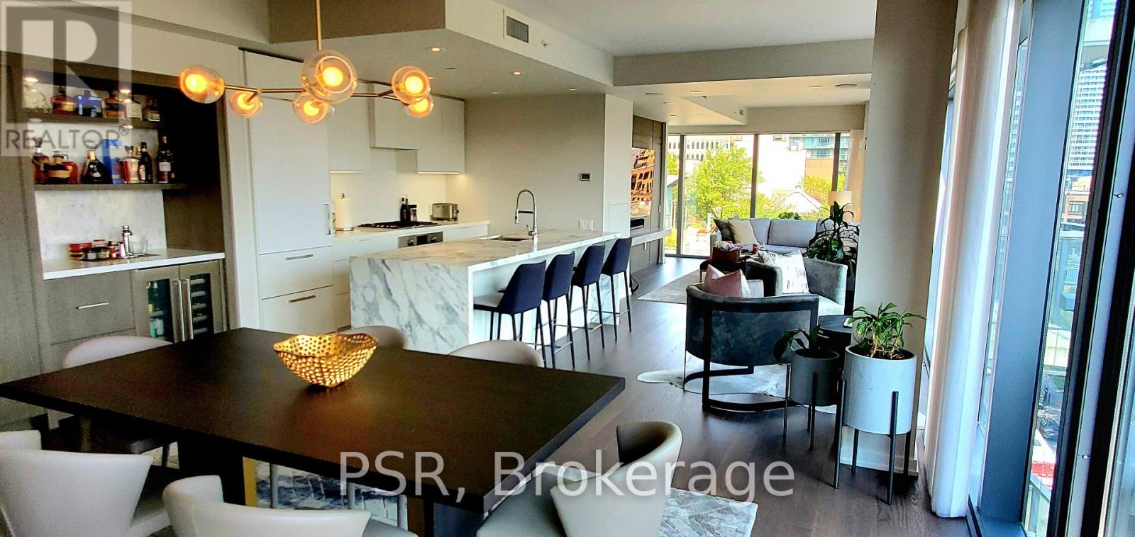 A modern dining room with a dark table and chairs.