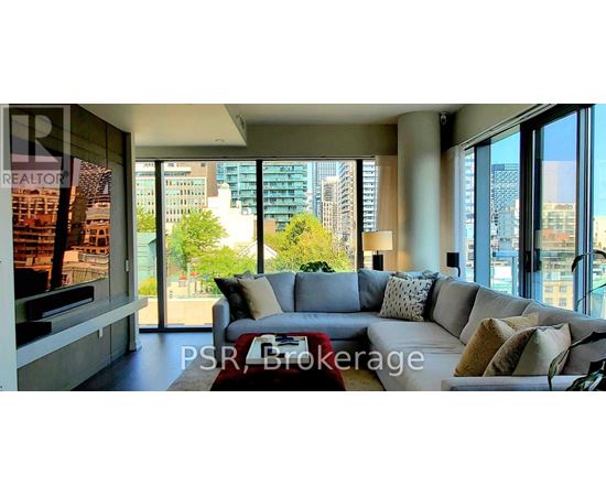 A living room with a grey couch and a red coffee table.