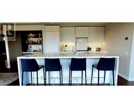 A kitchen with a bar stool in front of it.