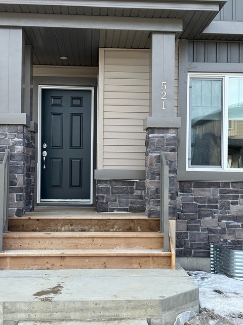 A house with a black door and a stone pillar.