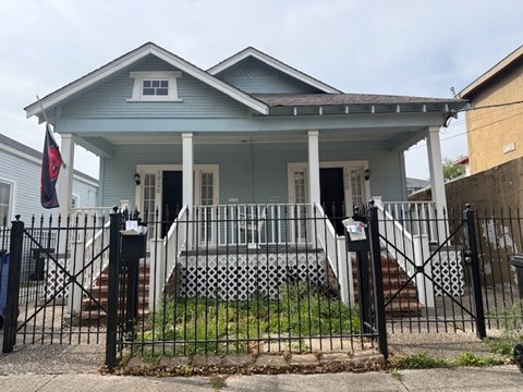 A blue house with a black gate in front.