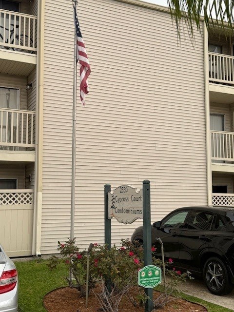 A sign in front of a building that says "1300 Congress Court" and has a flag on top.