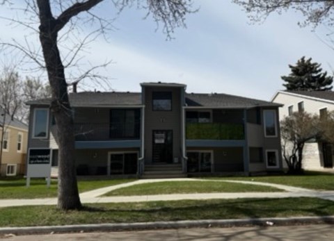 A modern house with a tree in front.