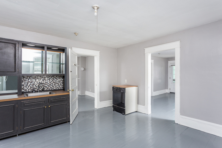 A kitchen with a black counter top and a white fridge.