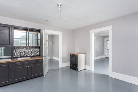 A kitchen with a black counter top and a white fridge.