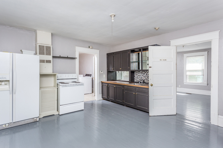 A kitchen with white appliances and cabinets.