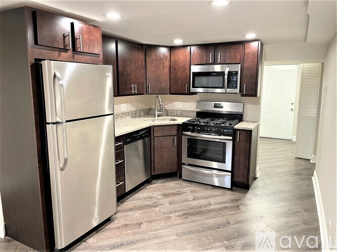 A kitchen with a stainless steel refrigerator, microwave, oven, and dishwasher.