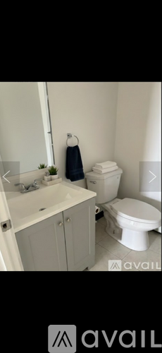 A white toilet sits next to a white sink in a bathroom.
