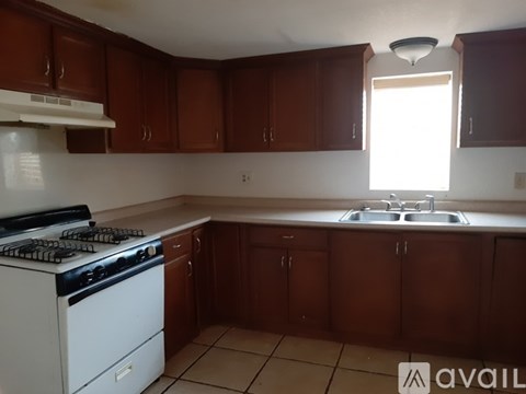 A kitchen with brown cabinets and a white stove.