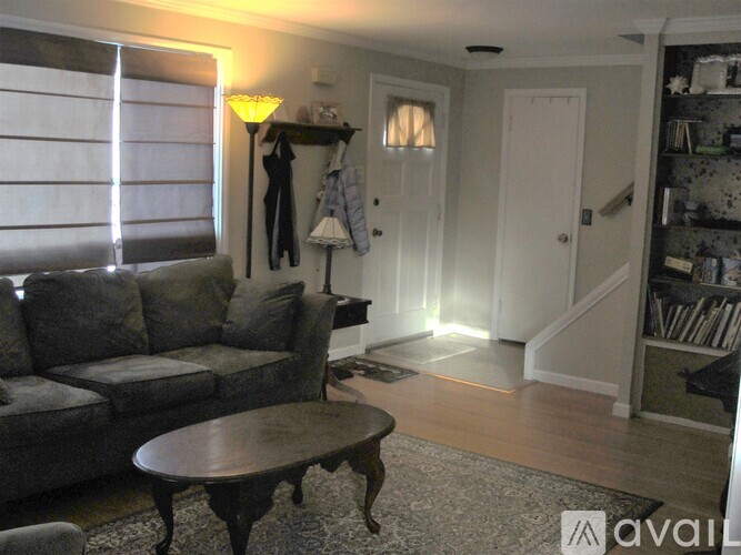 A living room with a grey couch and a wooden coffee table.