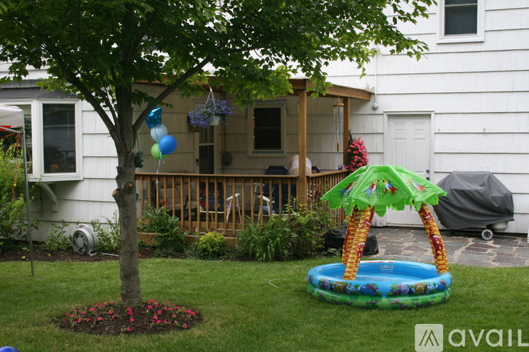 A tree with a pineapple shaped inflatable pool float in the foreground.