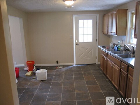 A kitchen with brown cabinets and a white door.