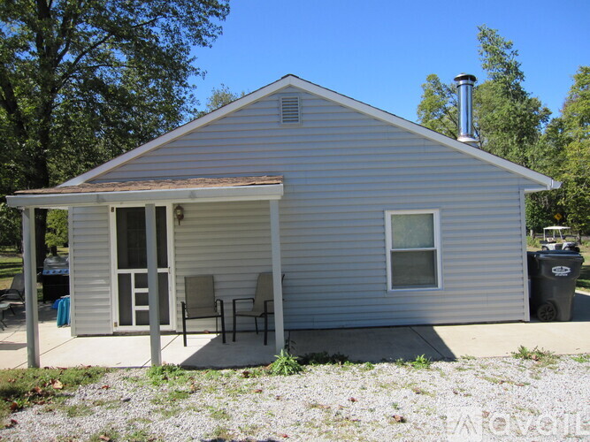 A small house with a covered patio and a chimney.