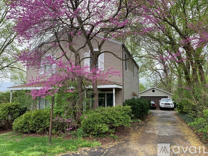 A house with a driveway and a car parked in front.