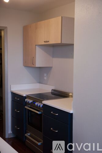 A kitchen with a white counter top and blue drawers.