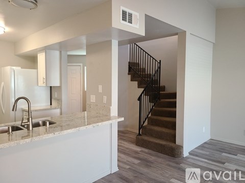 A kitchen with a sink and a staircase.