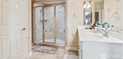 A bathroom with a sink, mirror, and shower.