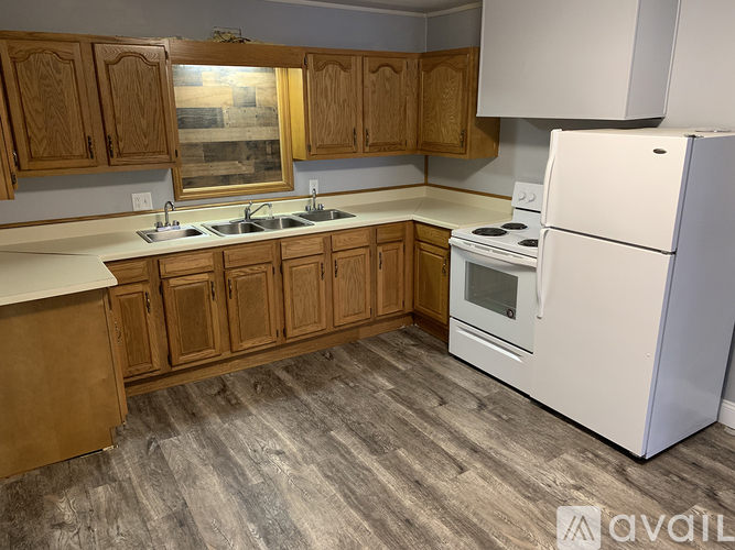 A kitchen with wooden cabinets and a white refrigerator.