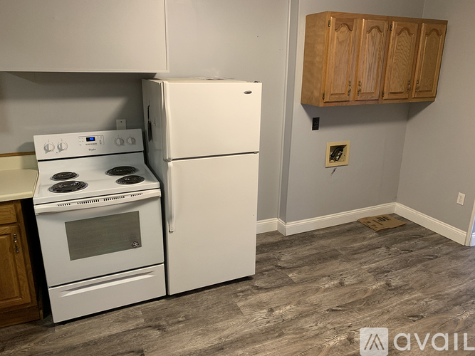 A kitchen with a white stove and refrigerator.