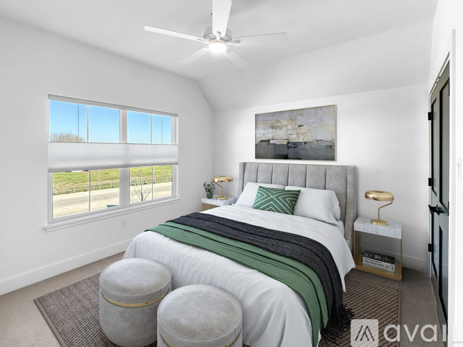 A bedroom with a large bed and a ceiling fan.