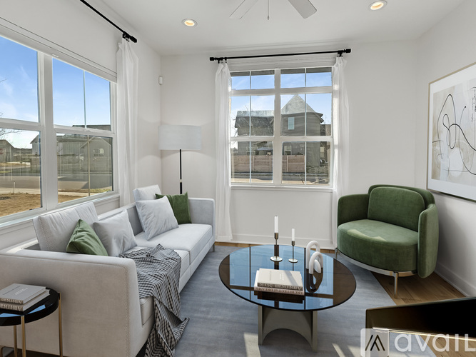 A living room with a white couch, green armchair, and a coffee table.