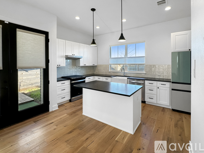A modern kitchen with white cabinets and a black island.
