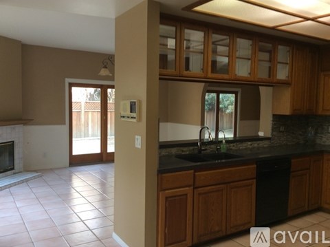 A kitchen with a black counter top and wooden cabinets.
