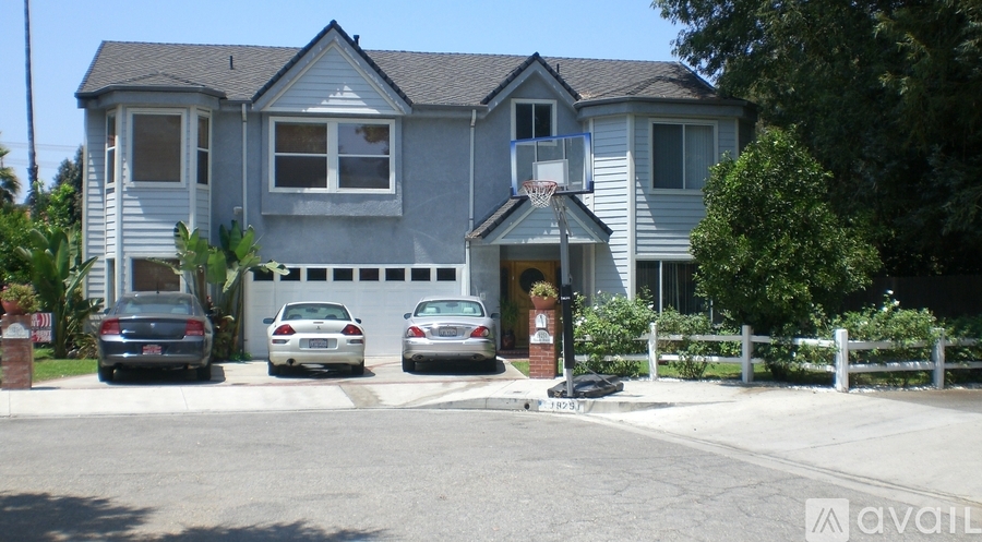 A house with a grey exterior and a white fence in front.