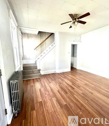 A room with wooden floors and a ceiling fan.