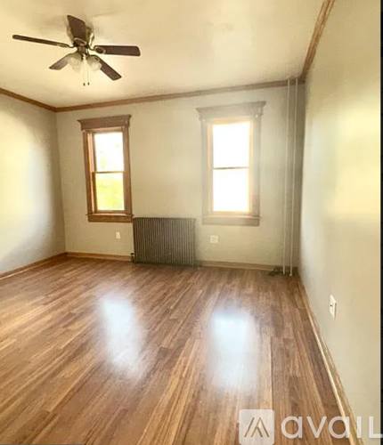 A room with wooden floors and a ceiling fan.