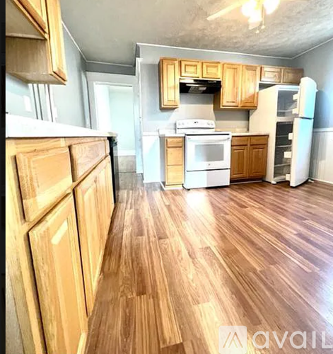 A kitchen with wooden cabinets and a white fridge.