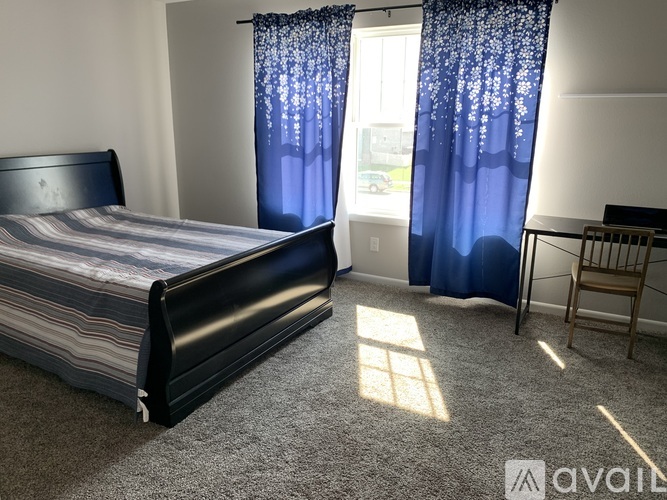 A bedroom with a large bed and a chair.