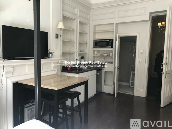 A kitchen with a table and chairs and a television.