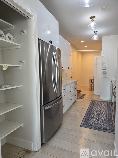 A kitchen with a refrigerator and a drawer.
